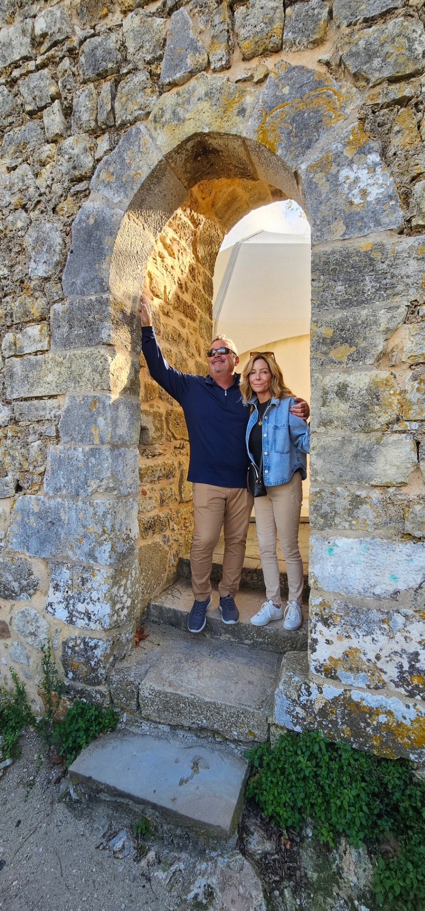 Couple framed by a medieval stone arch on the Óbidos walls