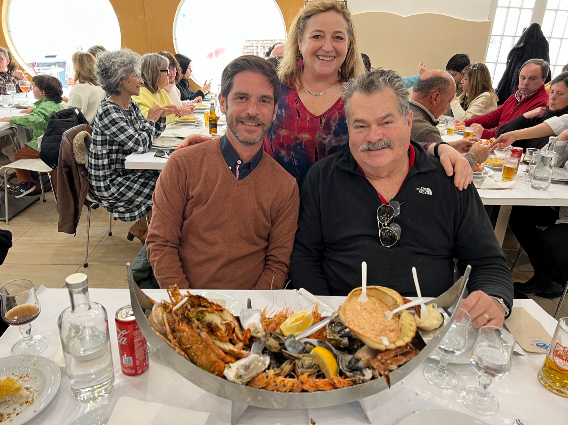 Guests around a heaping seafood platter at a Nazaré marisqueira