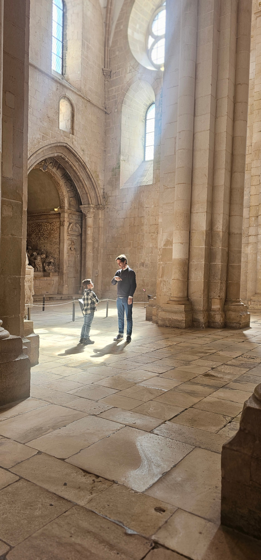Eduardo speaking with a young guest inside the vast nave of Alcobaça Monastery