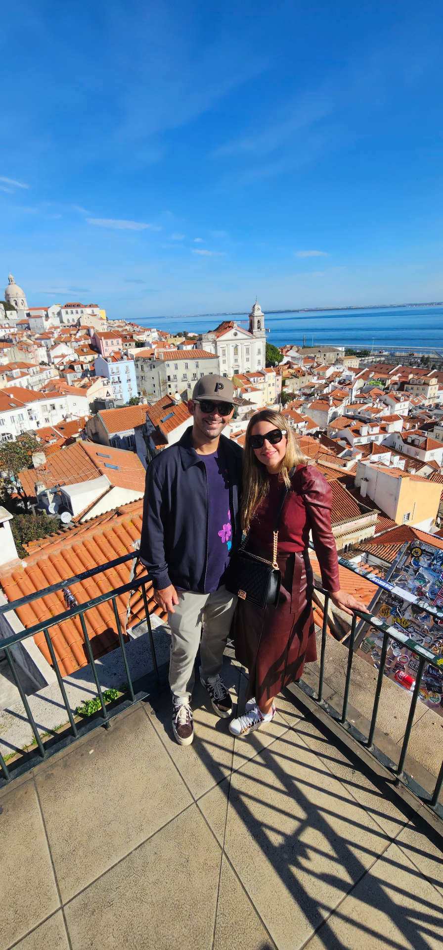 Couple overlooking Alfama's rooftops and the Tagus