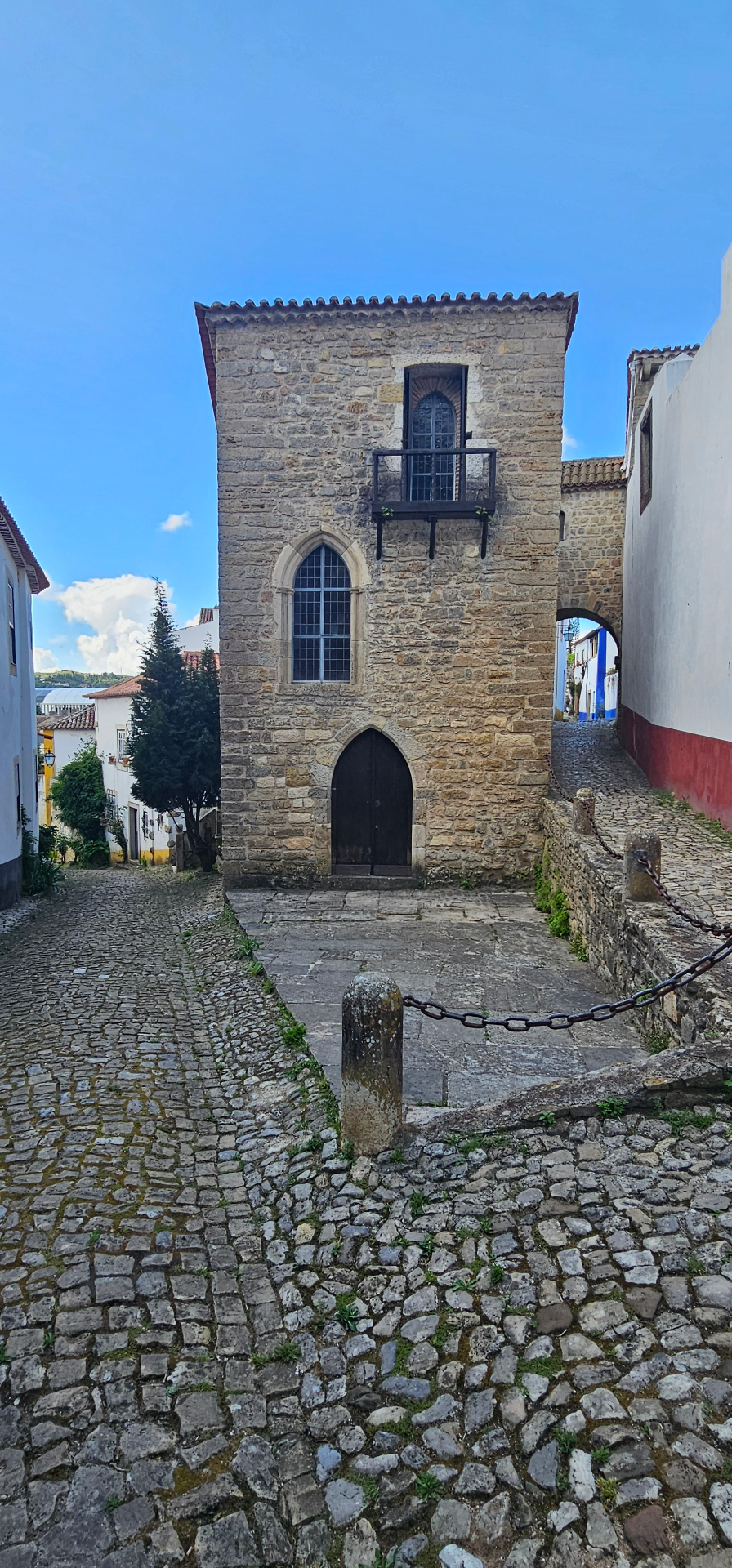 A gothic stone house on a quiet cobbled square inside the walls of Óbidos