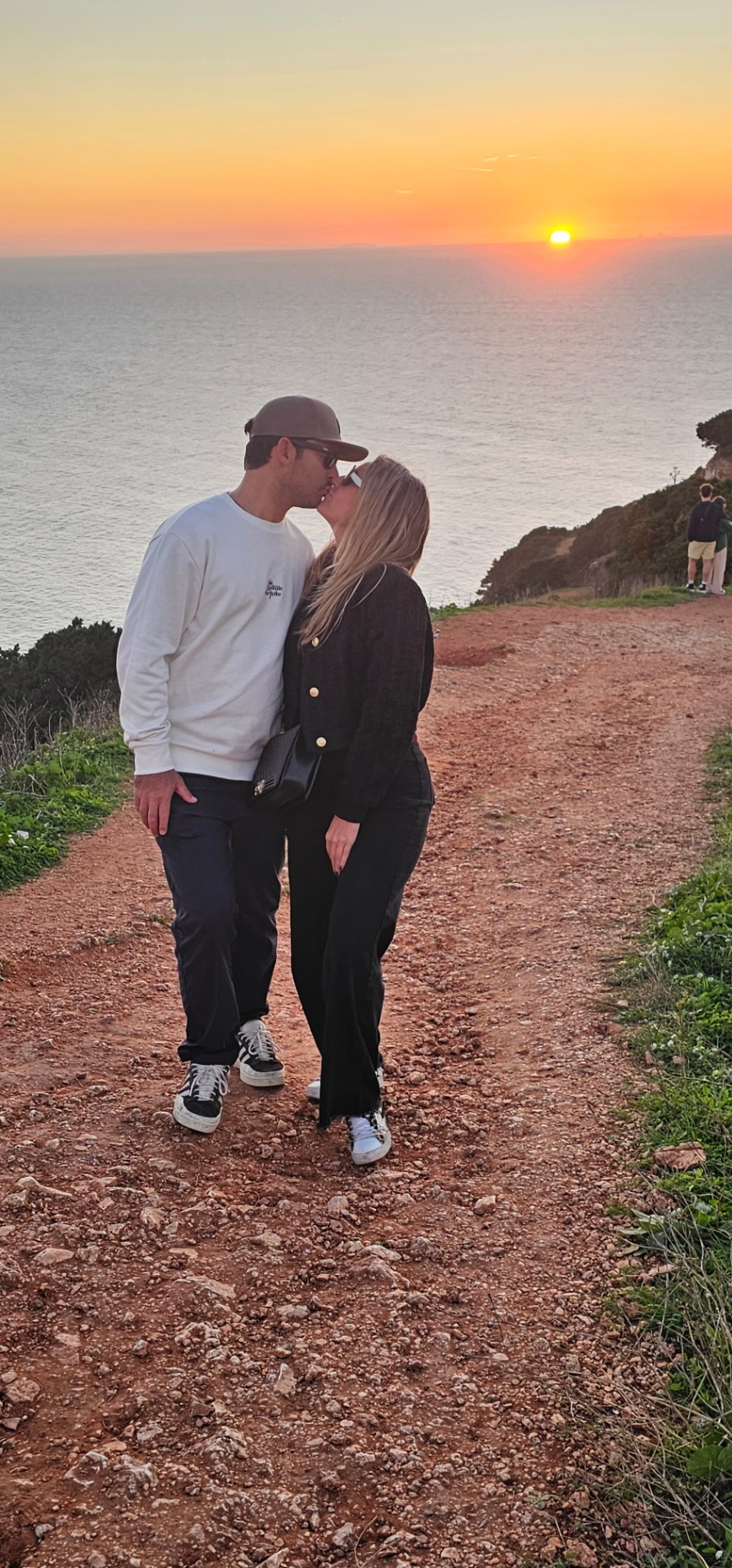 Couple at a Silver Coast clifftop viewpoint at sunset